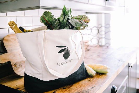 La Belle Excuse large white reusable tote bag with a black trim.